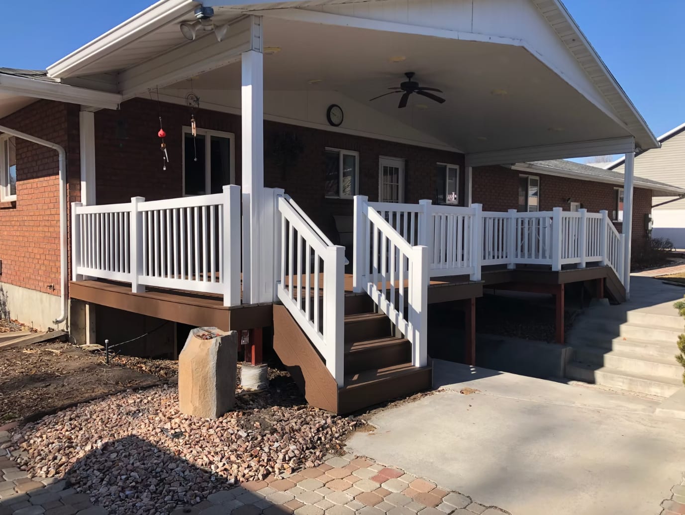Covered backyard deck with white railings and shade structure in Utah